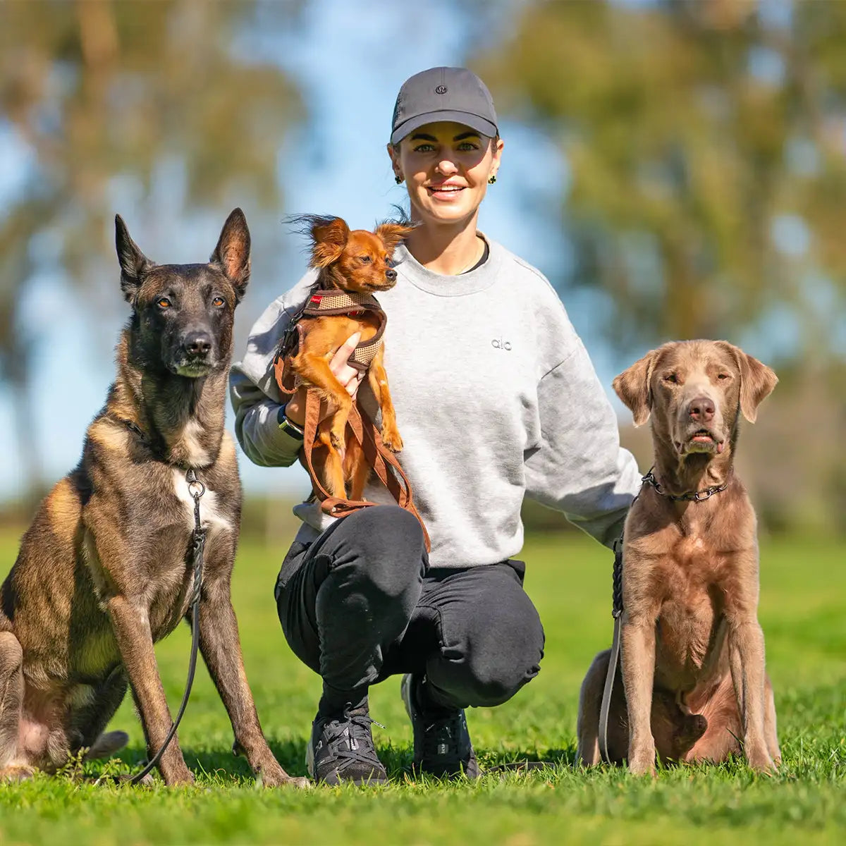 Veronika kneeling with her 3 dogs